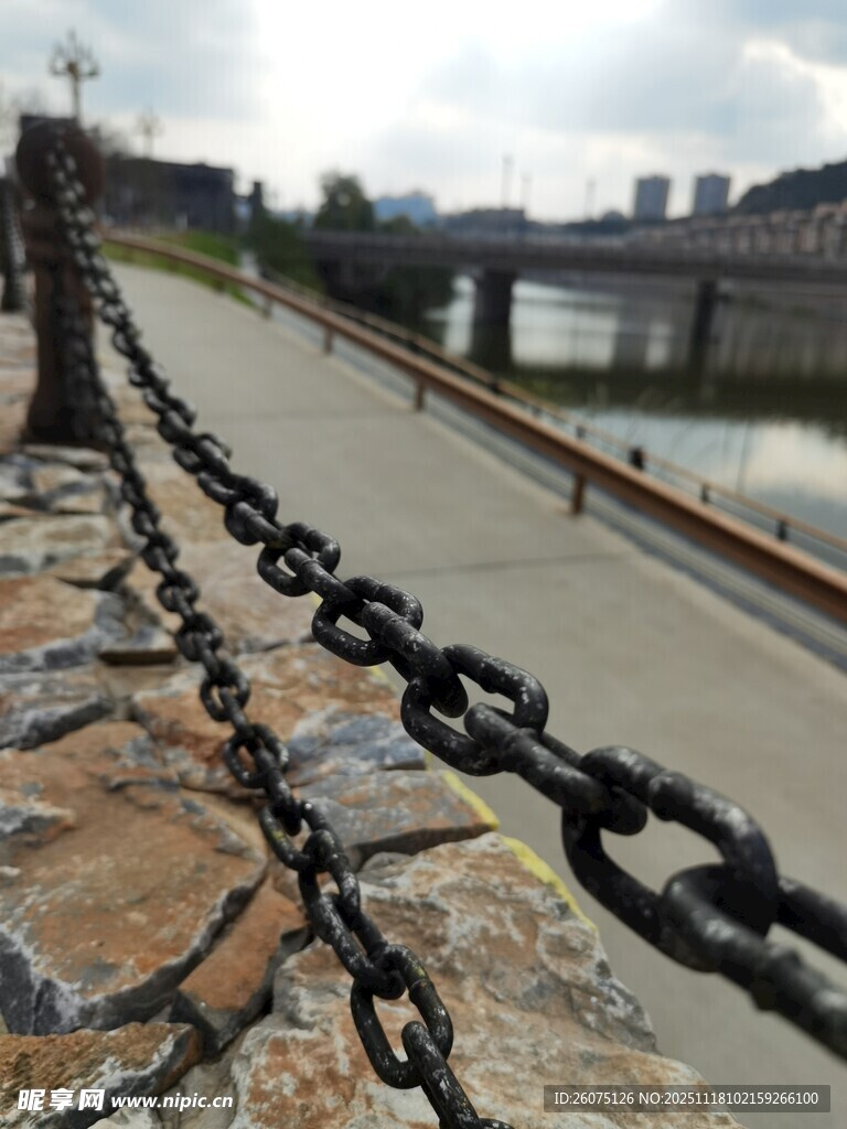 河畔铁链围栏与远处桥梁