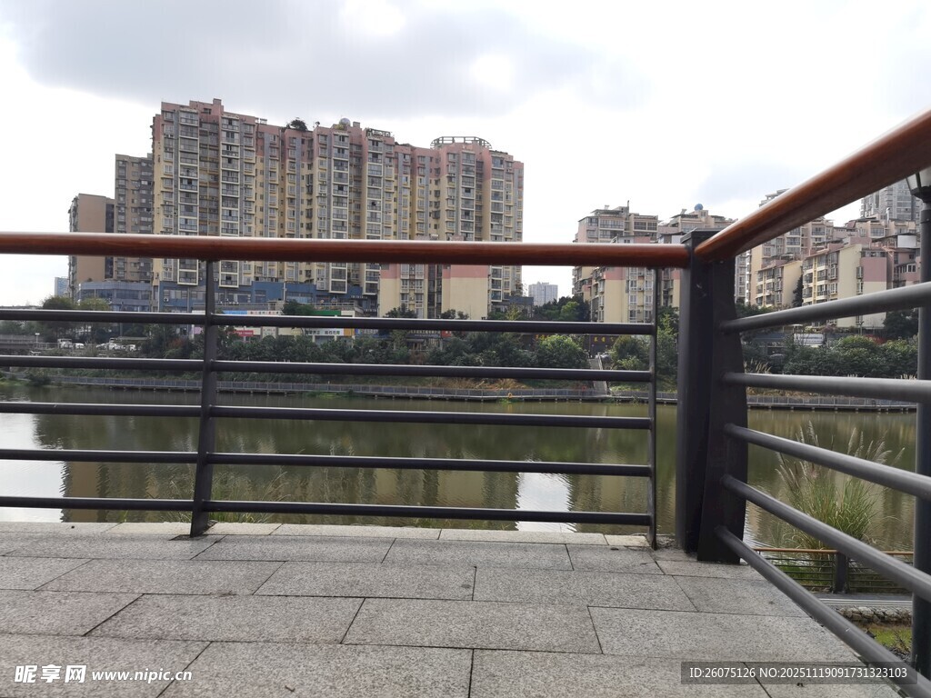 河畔栏杆旁的城市建筑景观
