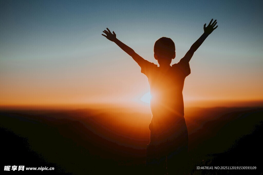 夕阳下张开双臂的人物剪影