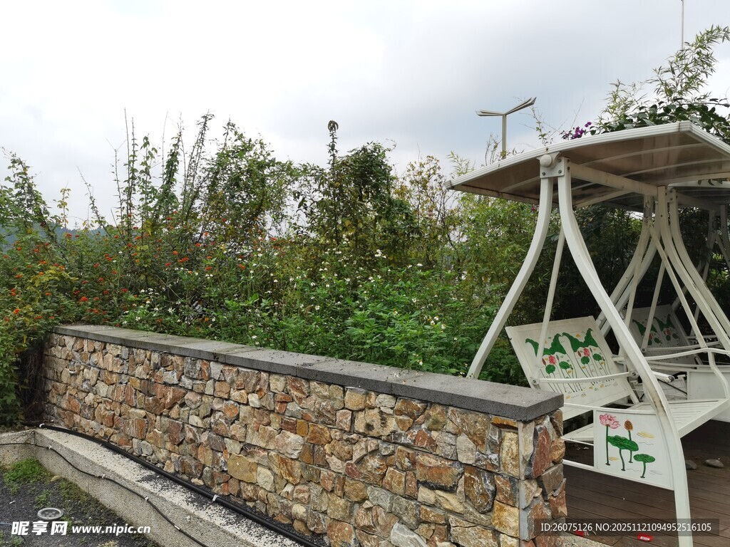 户外石墙旁的白色凉亭