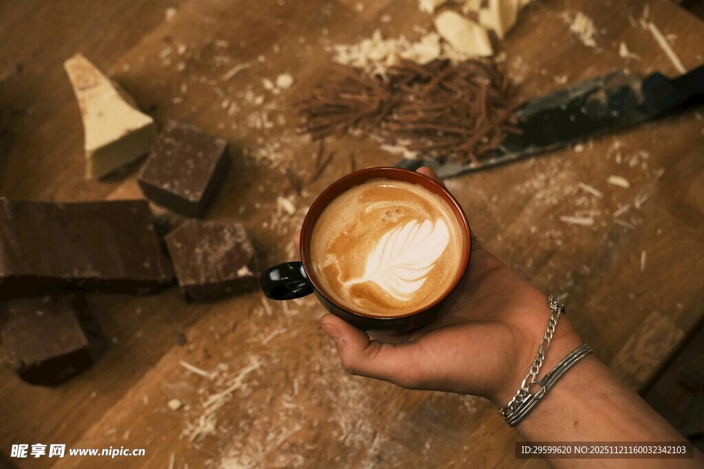 手捧精美拉花的醇香咖啡