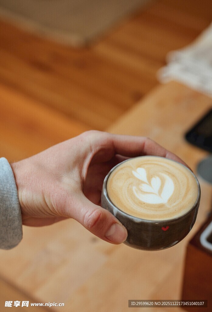 手持精美拉花的一杯咖啡