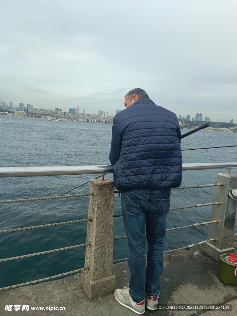 男子凭栏眺望远方海景