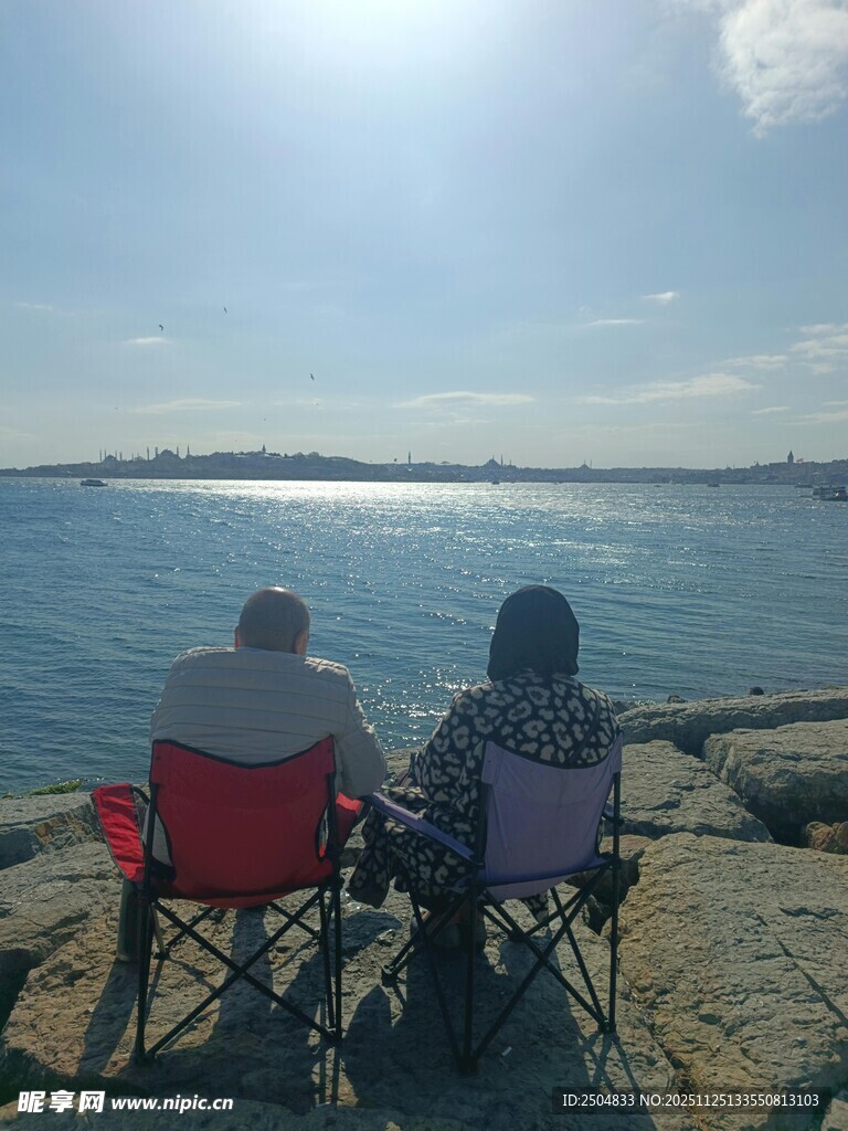 海边椅上两人共赏海景