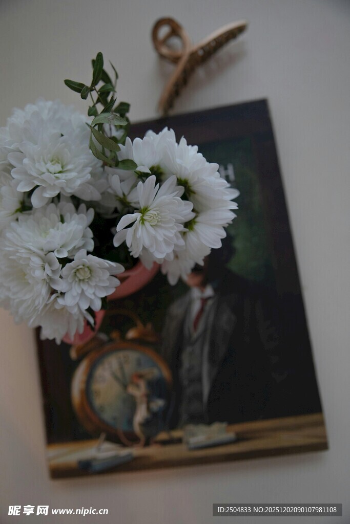 复古画作旁的素雅白花束