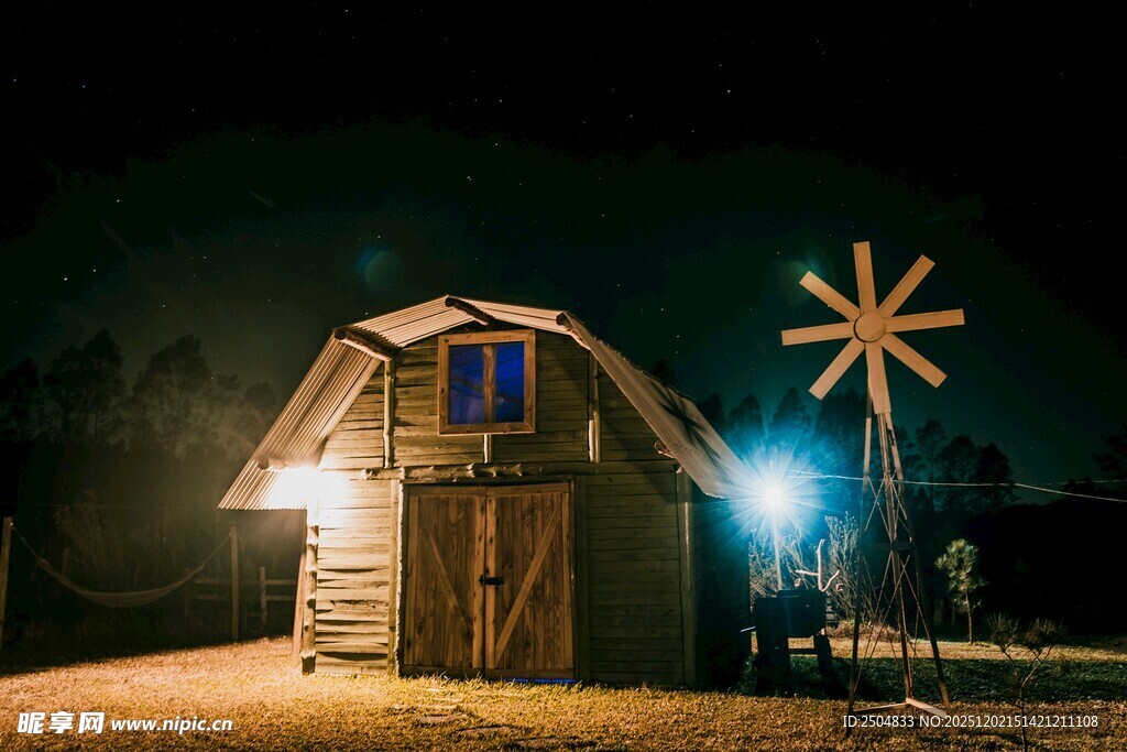 夜晚小屋旁的发光风车