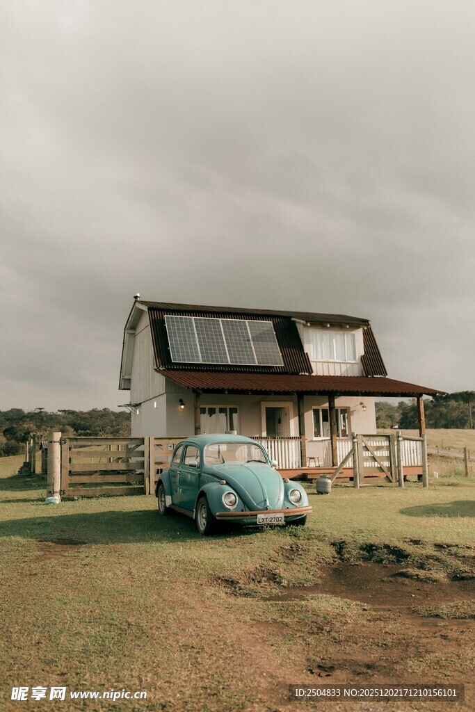 乡村旧屋旁的复古蓝色汽车
