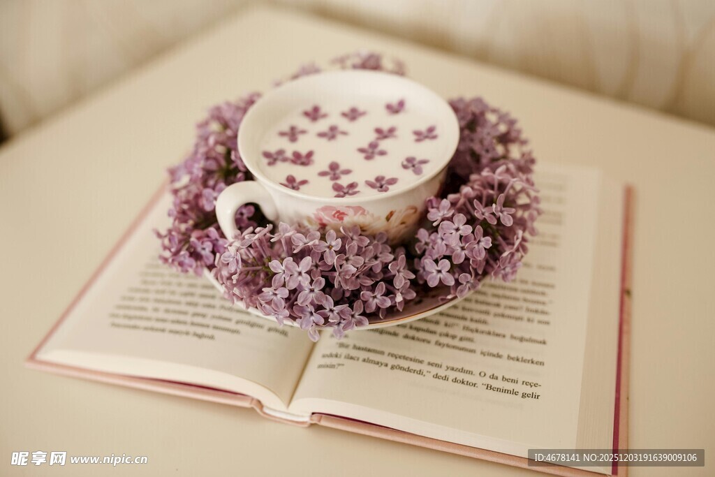 书本上带花环装饰的精致茶杯