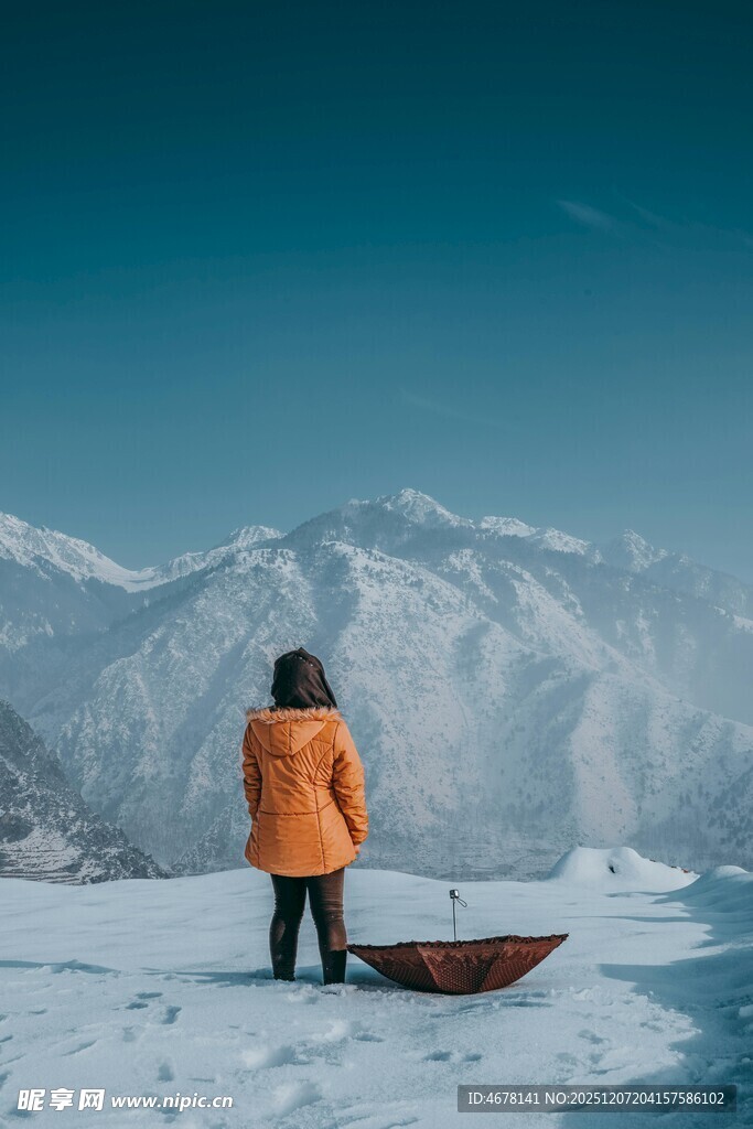 雪地持伞者眺望雪山