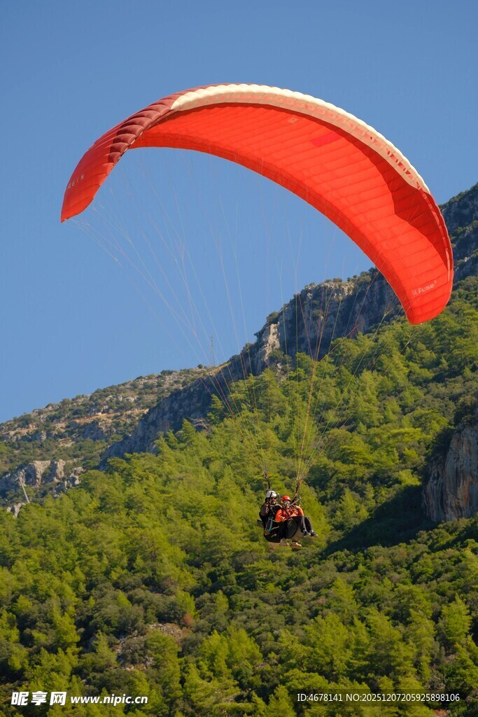 空中滑翔者翱翔青山之上