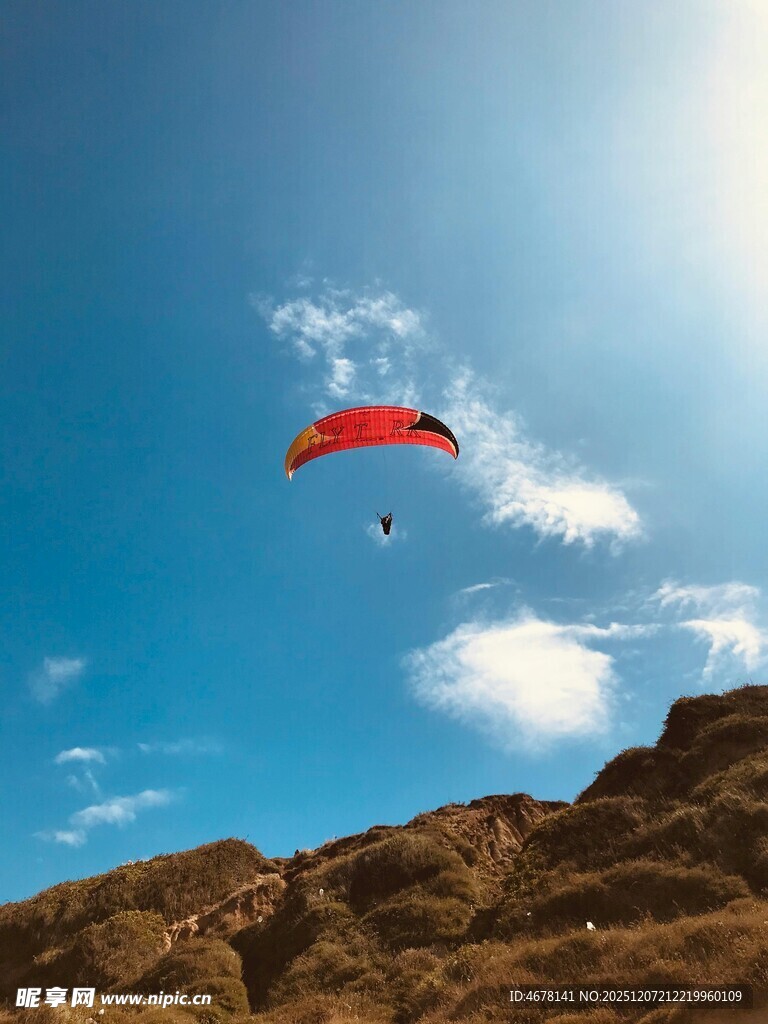 蓝天中翱翔的红色滑翔伞