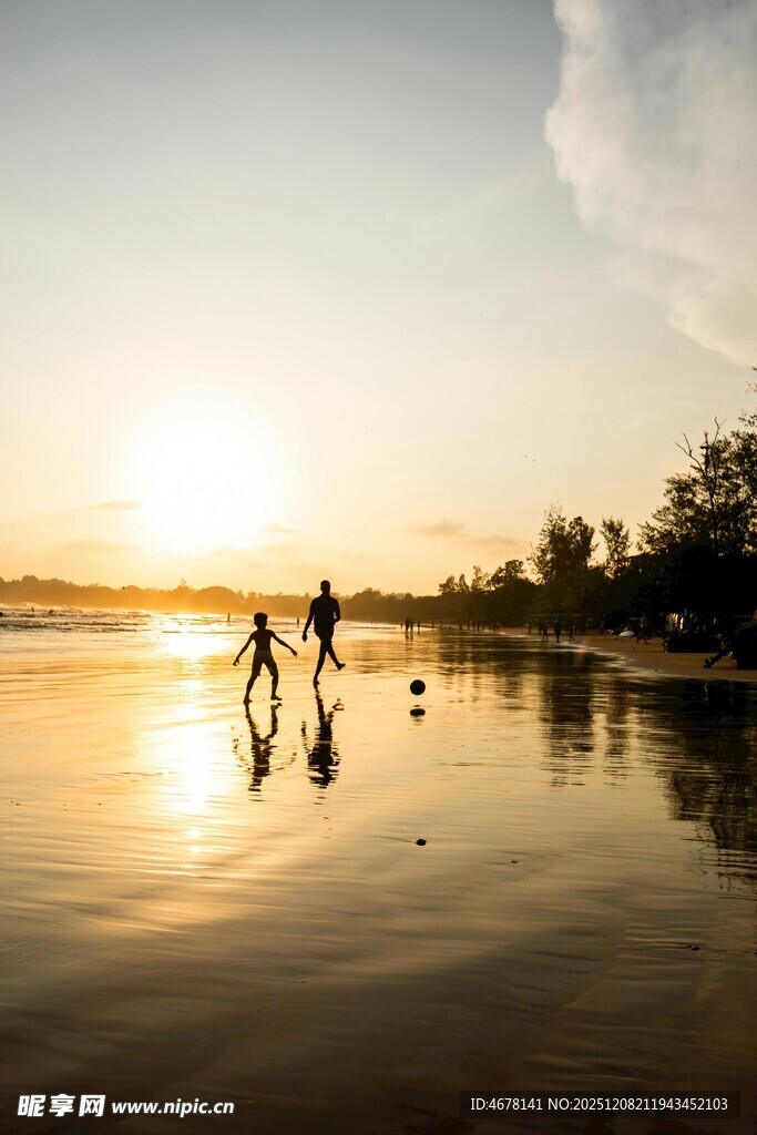 夕阳下漫步海滩的人们