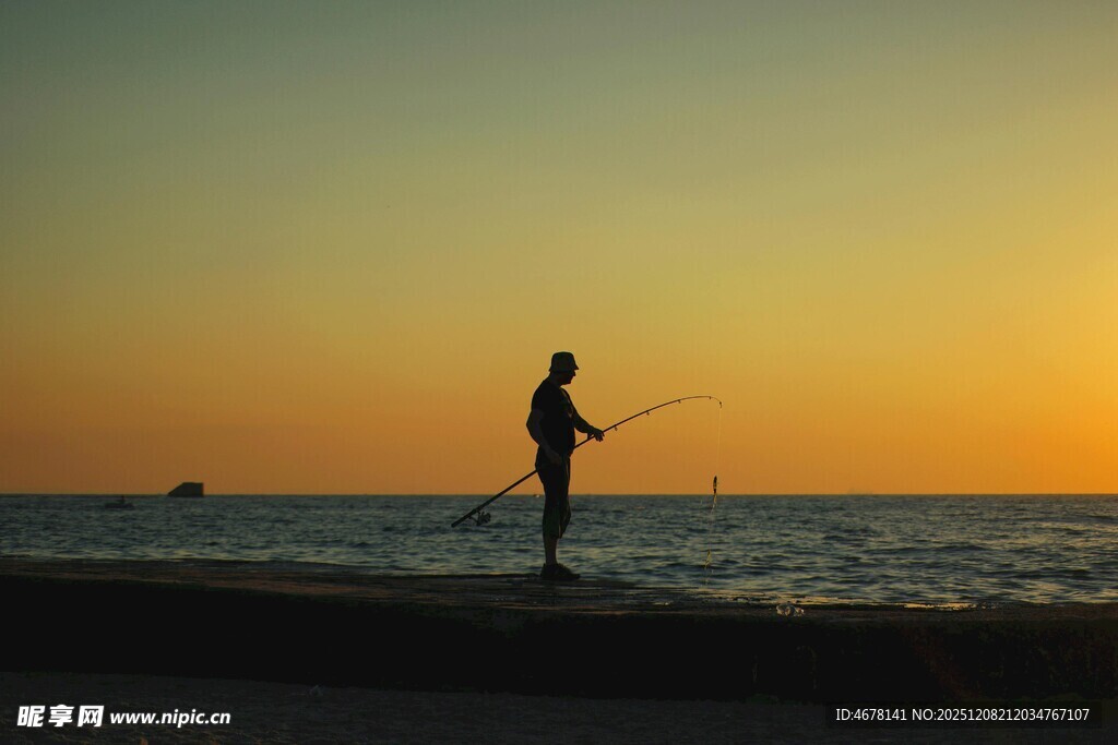夕阳下的海边垂钓者