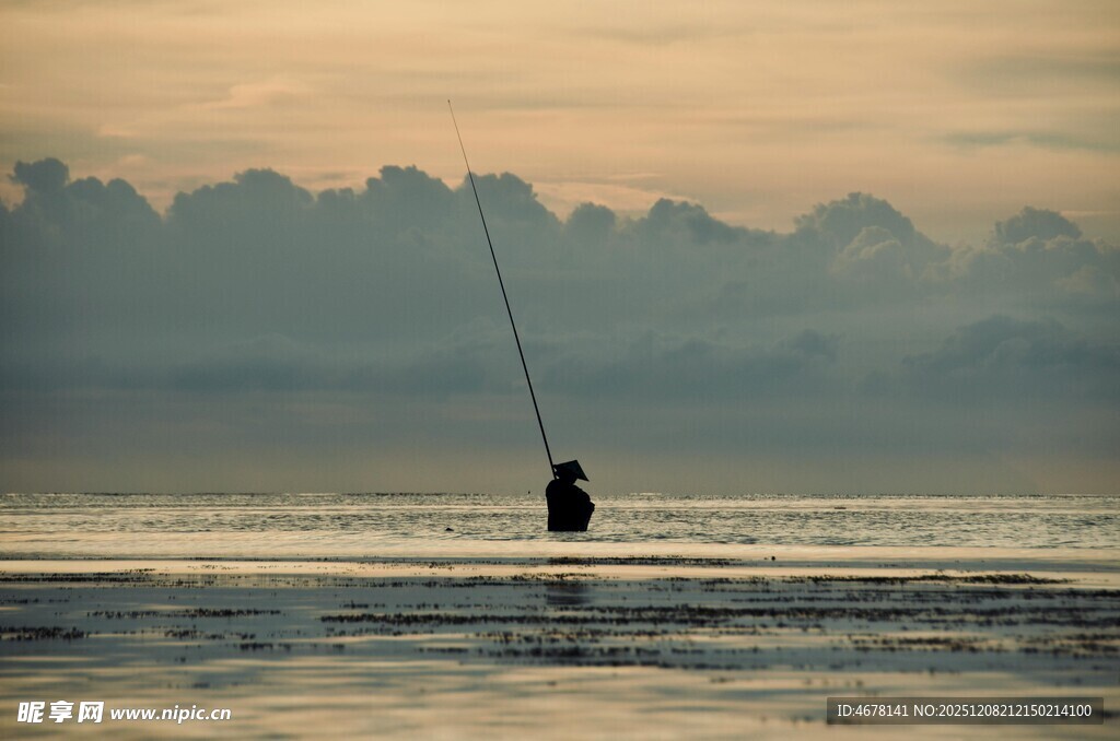 夕阳下的海边垂钓者