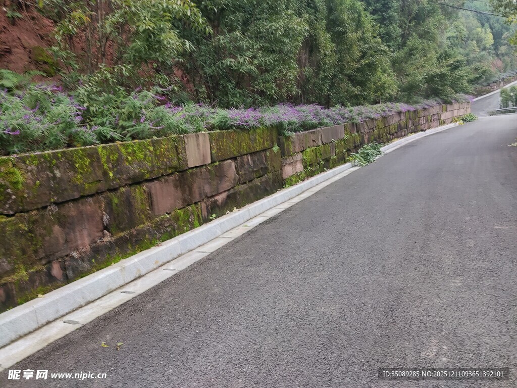 山间石砌路边的柏油道路