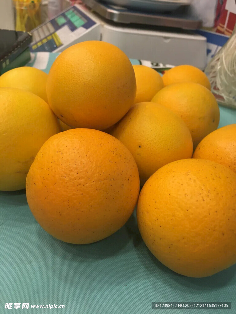 一堆新鲜橙子摆放在桌前