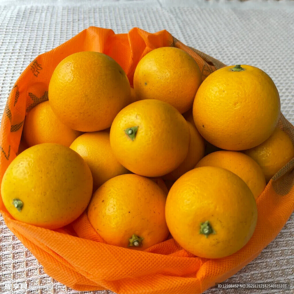 橙色布上盛放的新鲜橘子
