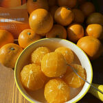 碗中鲜橙与堆放在旁的橙子