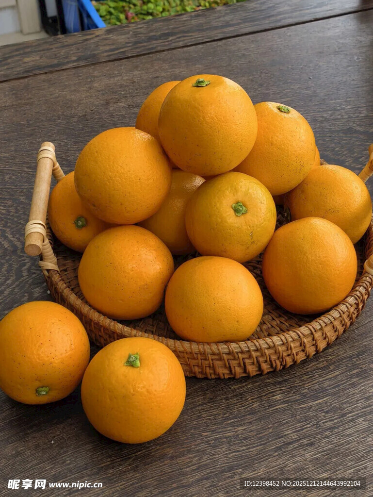 木桌上竹篮里的新鲜橙子