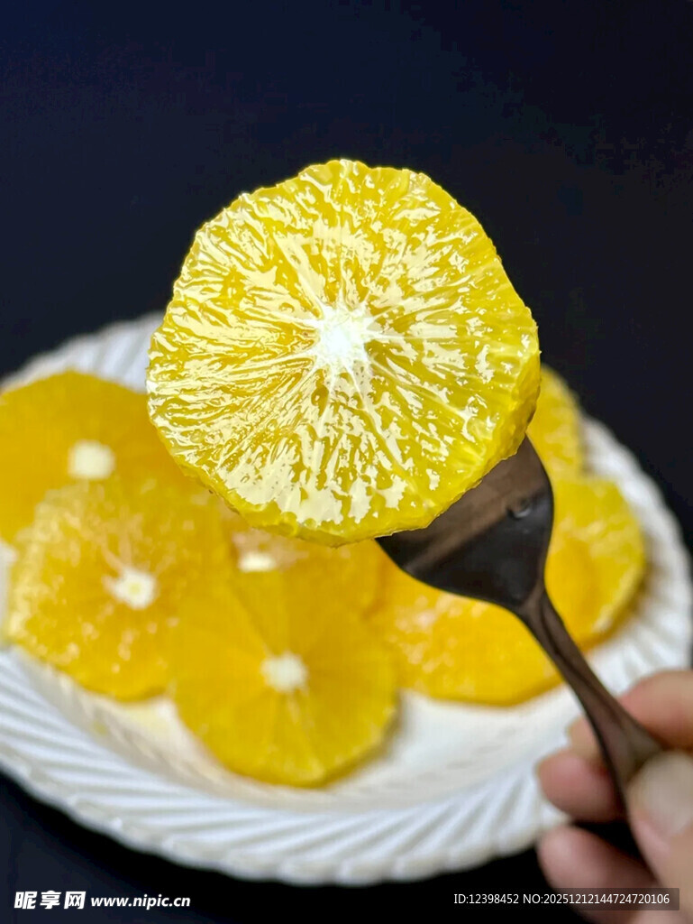 手持叉子的新鲜黄橙切片