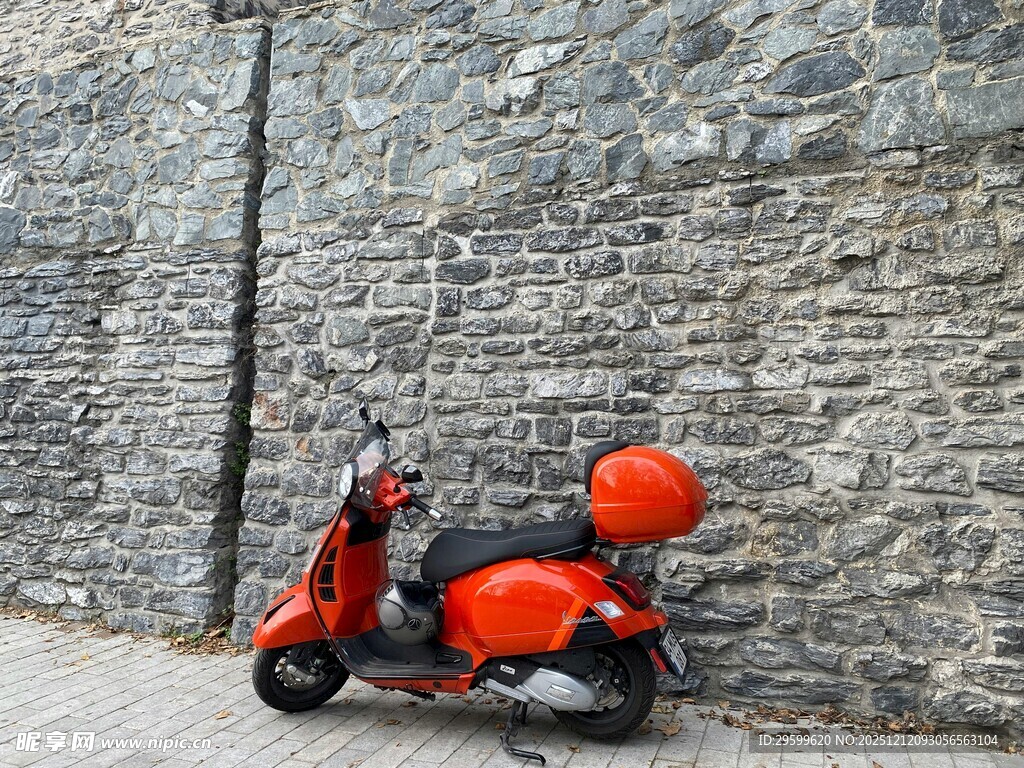 复古红色踏板摩托靠墙停放