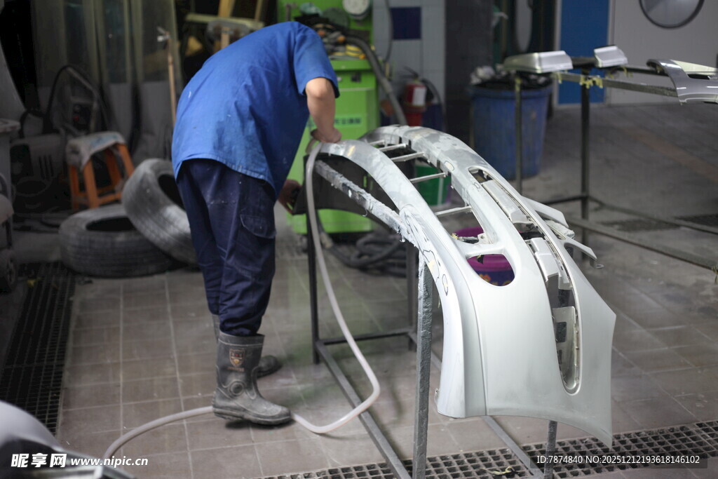 工人在车间喷涂汽车部件