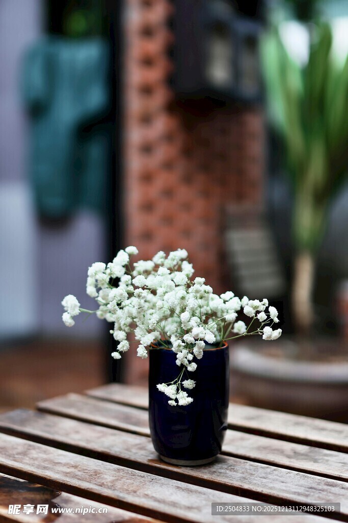 木桌上黑盆中的小白花