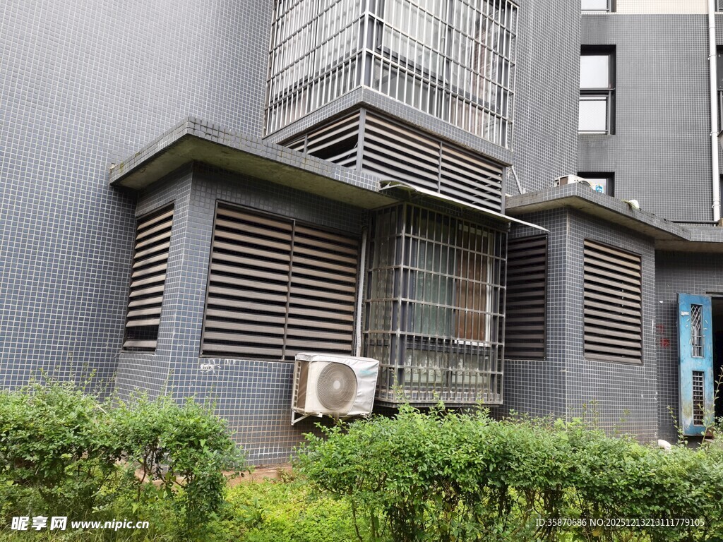 灰色建筑外的空调与绿植
