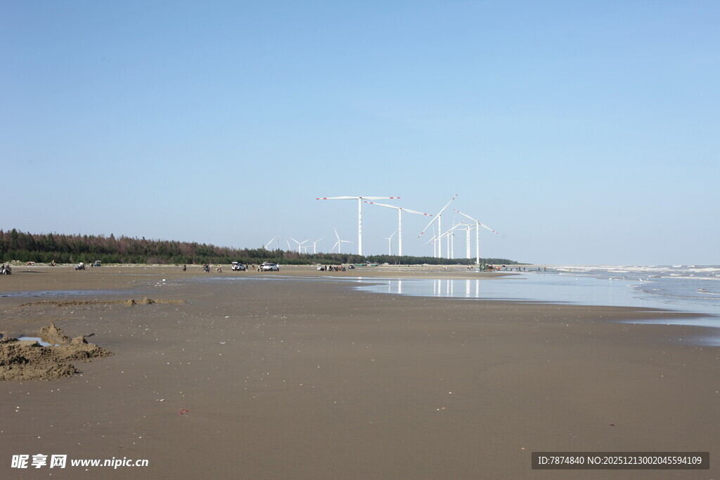 海边沙滩与远处风力发电机