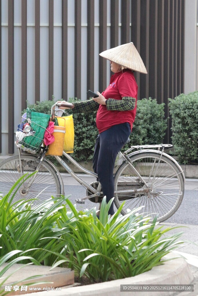 戴斗笠骑车的红衣商贩