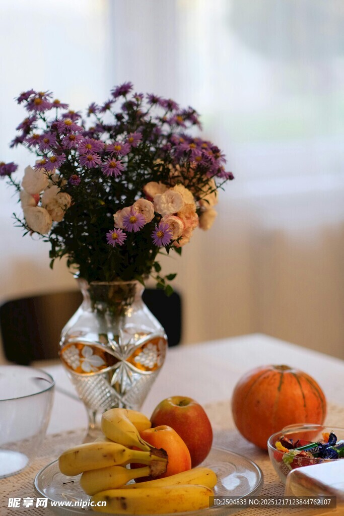 花瓶中的花与桌上水果