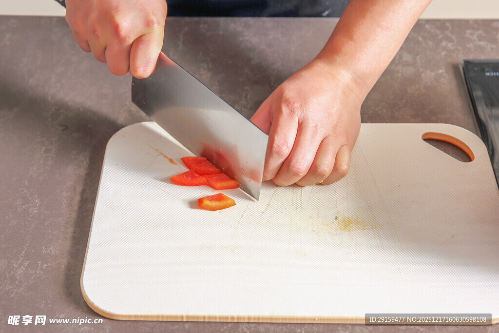厨师在案板上切红椒