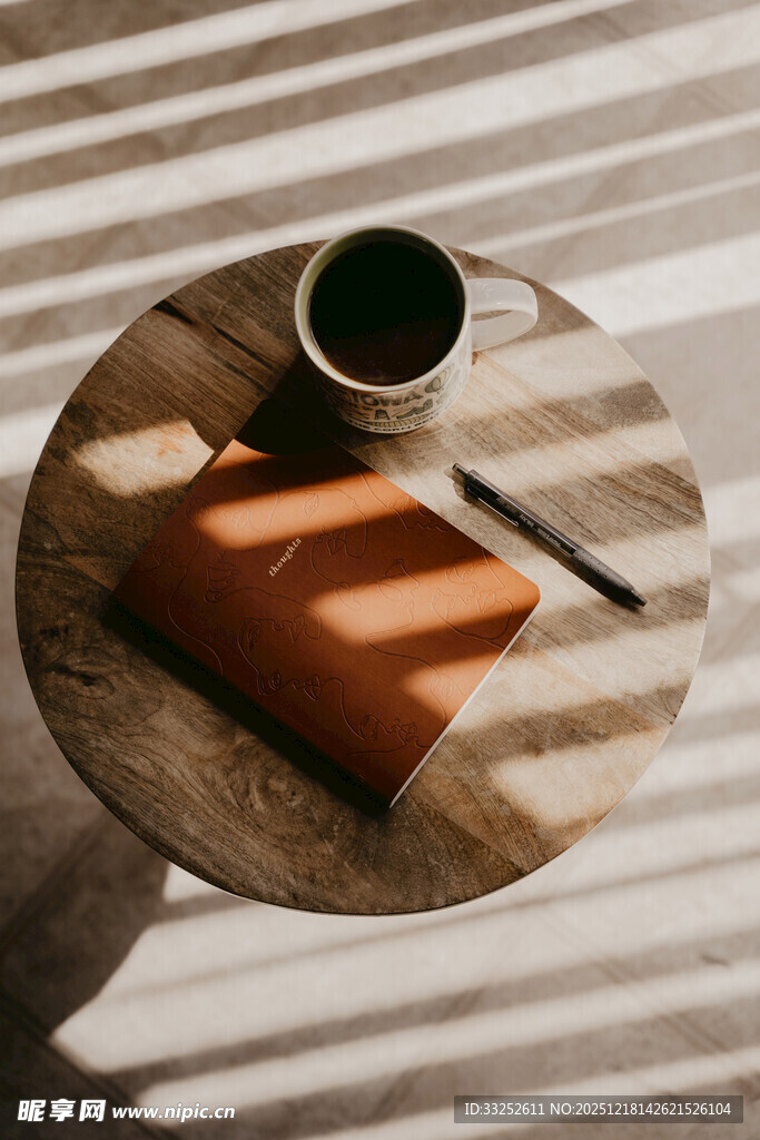 木质圆桌上的咖啡与笔记本