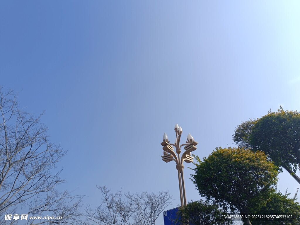 蓝天绿树间的装饰风车