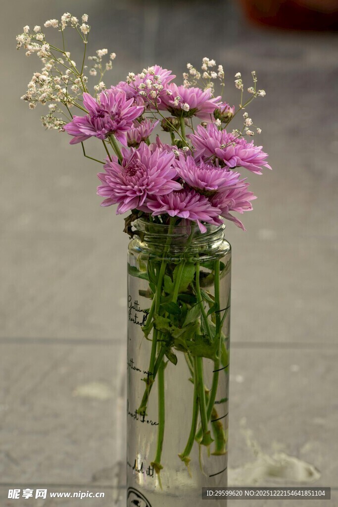 紫色小花插于透明玻璃瓶中