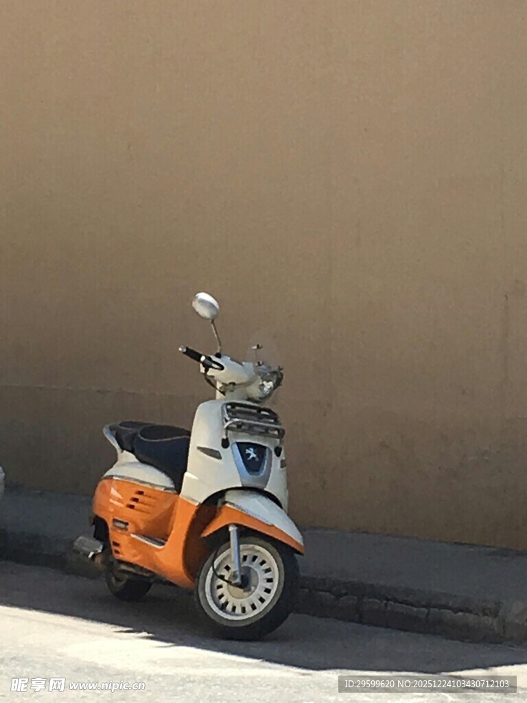 复古橙色小摩托靠墙而立