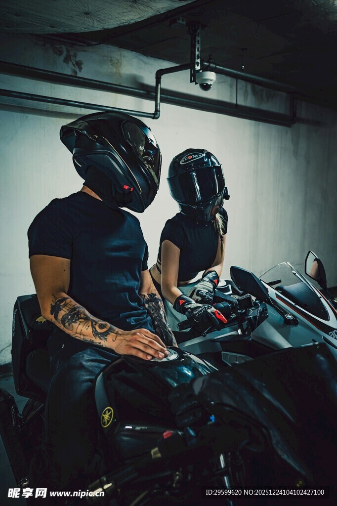 男子坐于摩托车上戴头盔
