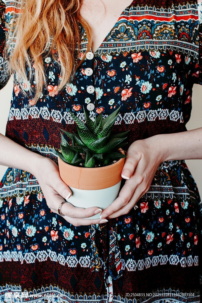 女子手持盆栽展示民族风服饰