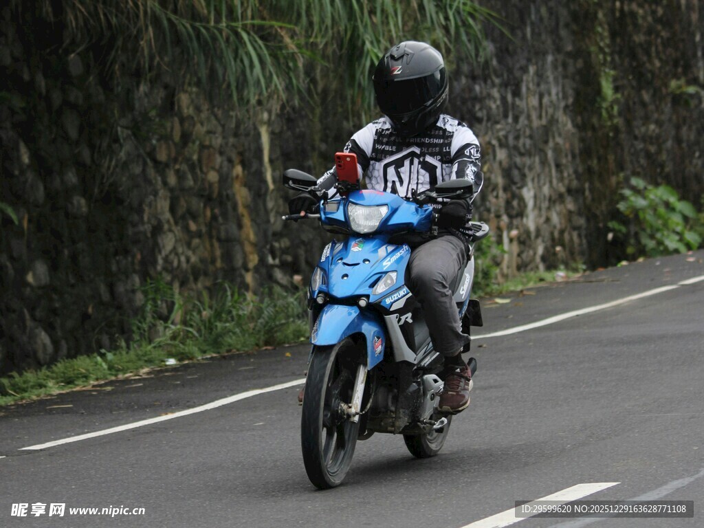 骑行者驾驶蓝色摩托车在路上