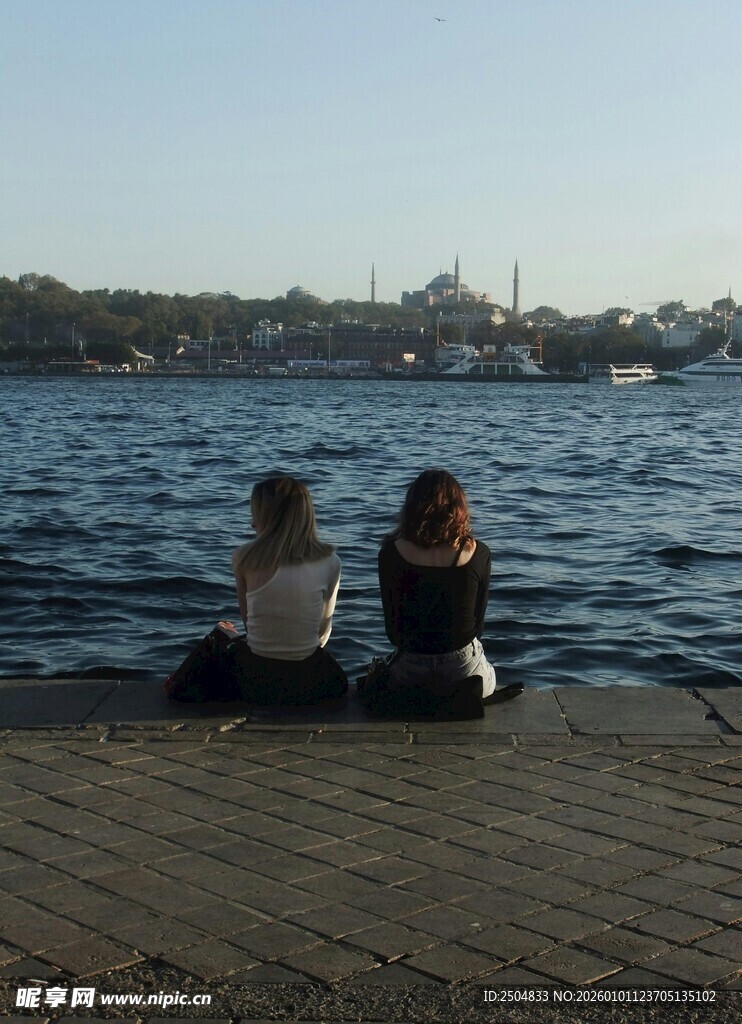 两人坐岸边赏辽阔水域