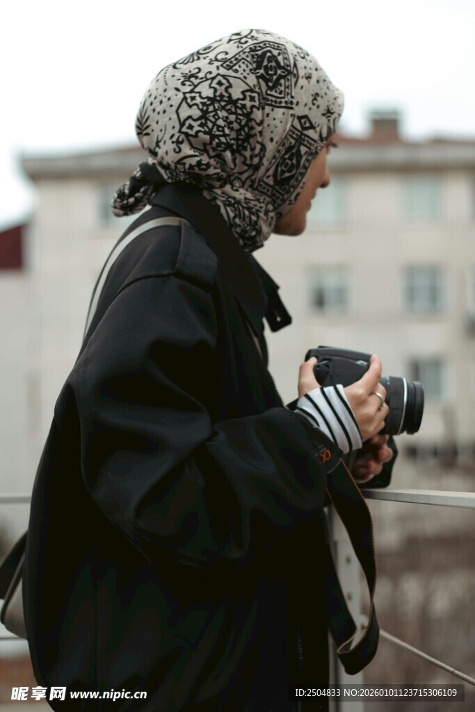 街头持相机的保暖装束者