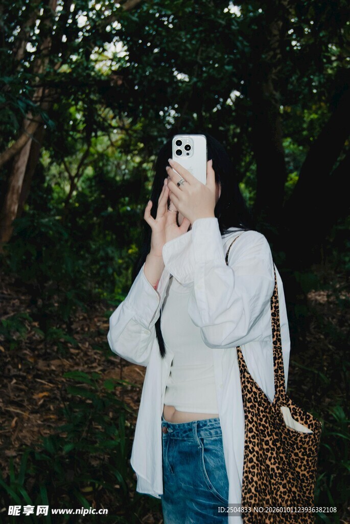 林中女子手持手机拍照