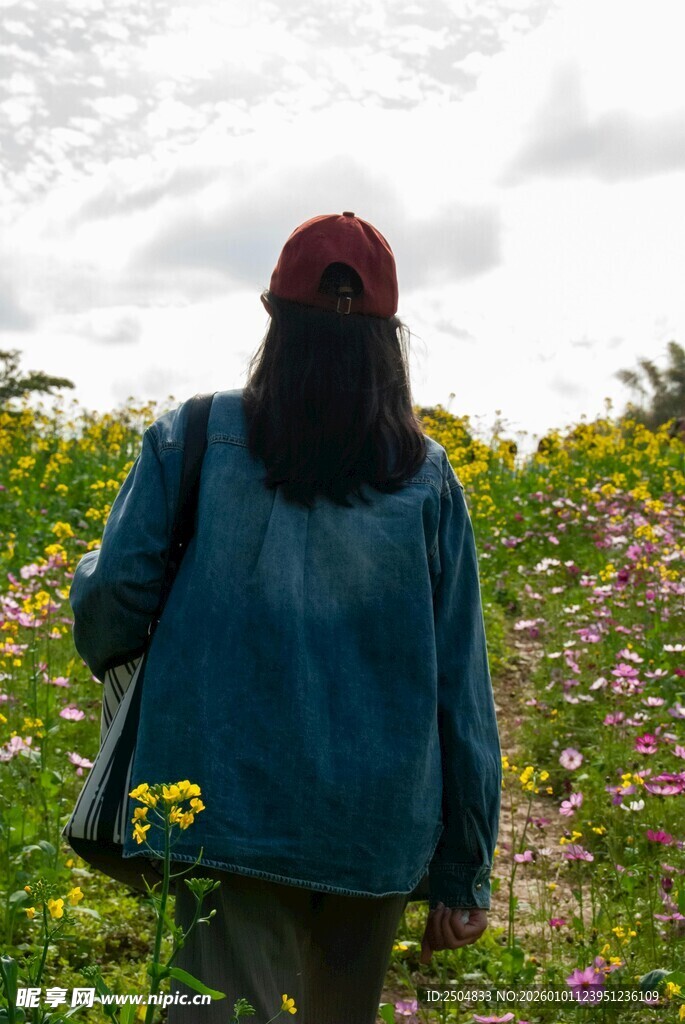 女子漫步繁花盛开的田野