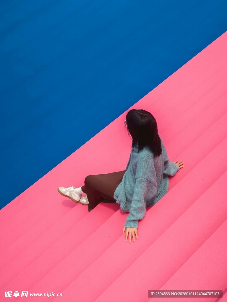 女孩坐于粉蓝拼接地面