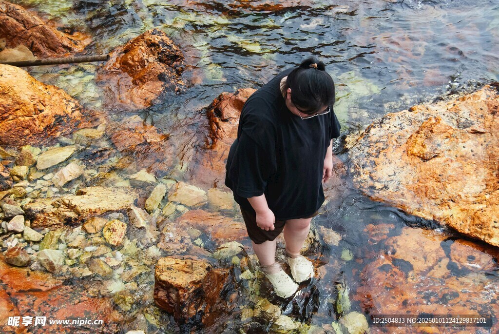 男子溪边赤脚踏行