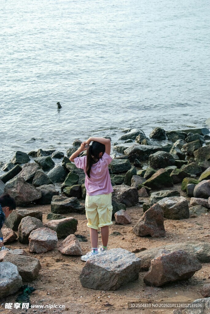 海边女孩于石间惬意伸展