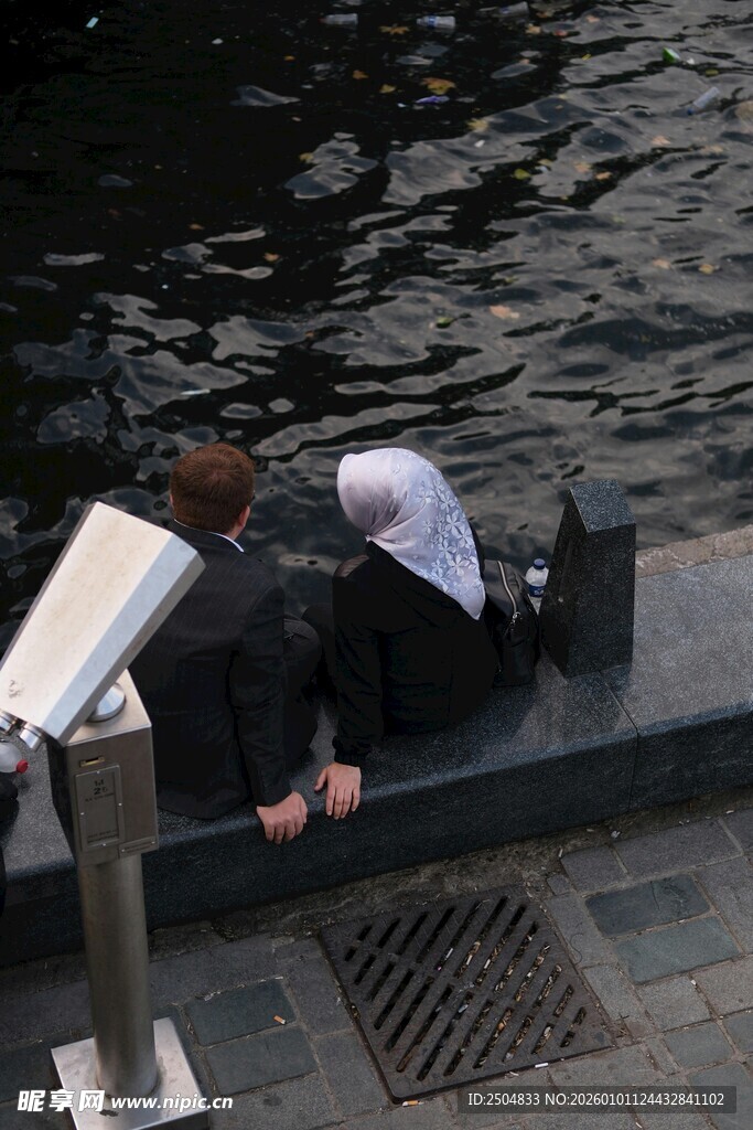 女子俯身水边专注观察