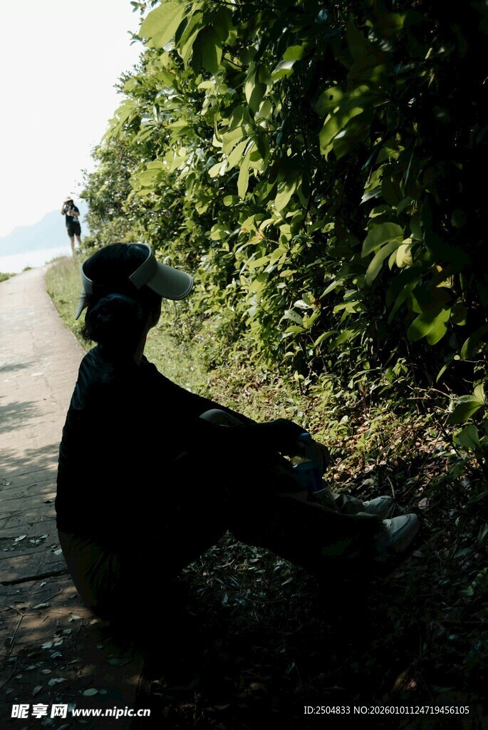 老人坐于绿荫下的静谧场景