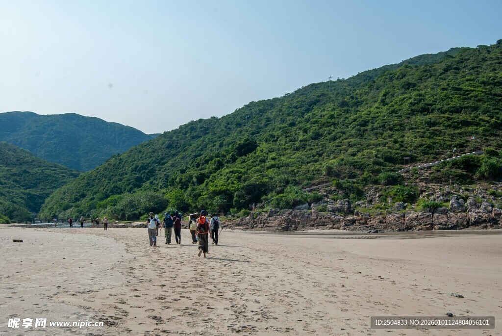 沙滩漫步的人群与青山