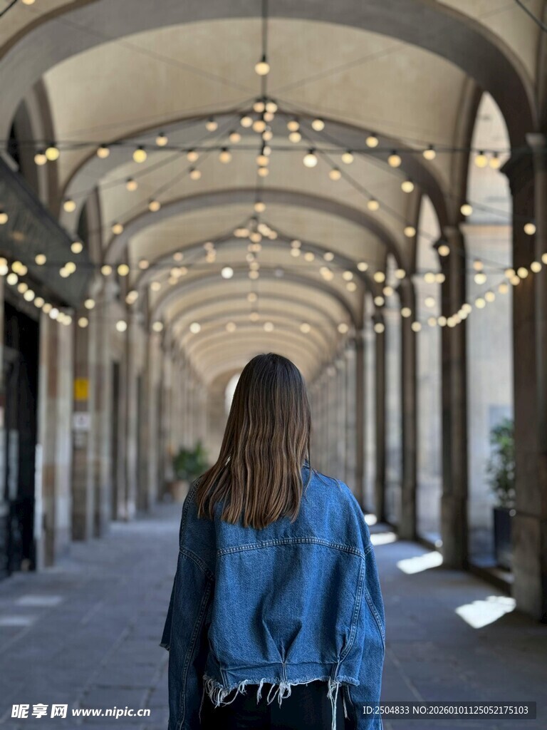 漫步拱形长廊的背影女子